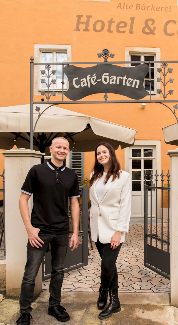 Gastgeberpaar vor dem Café-Garten der Alten Bäckerei